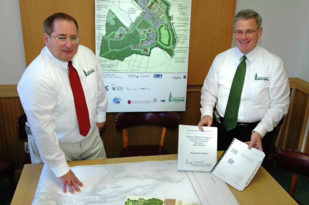Times Union staff photo by Lori Van Buren -- Saratoga Springs, NY - May 9, 2005 -- From left, Jack Kelly and Ken Green stand in the office of Saratoga Economic Development Corp with booklets and maps relating to the Luther Forest Technology Campus. It will soon be one year since the LFTC PDD was approved in Malta. For Ken Crowe story.