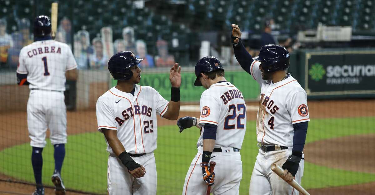 Houston Astros Michael Brantley (23), George Springer (4) and Josh Reddick (22) celebrate after Kyle Tucker's three-run triple during the first inning of game two of a double header during an MLB baseball game at Minute Maid Park, Saturday, August 29, 2020, in Houston.
