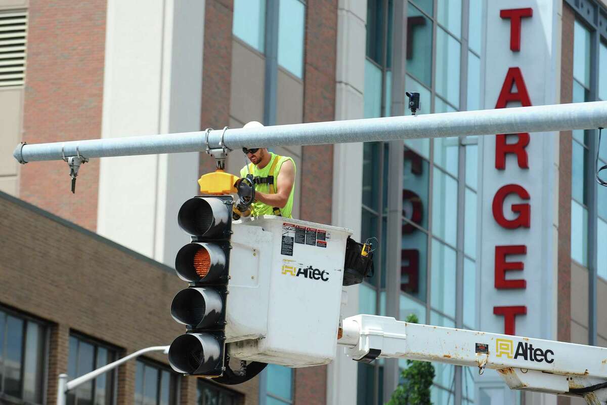 An Altec employee works on fixing a traffic light at the corner of Summer St. and Broad St. in downtown Stamford on Friday, July 15, 2016.