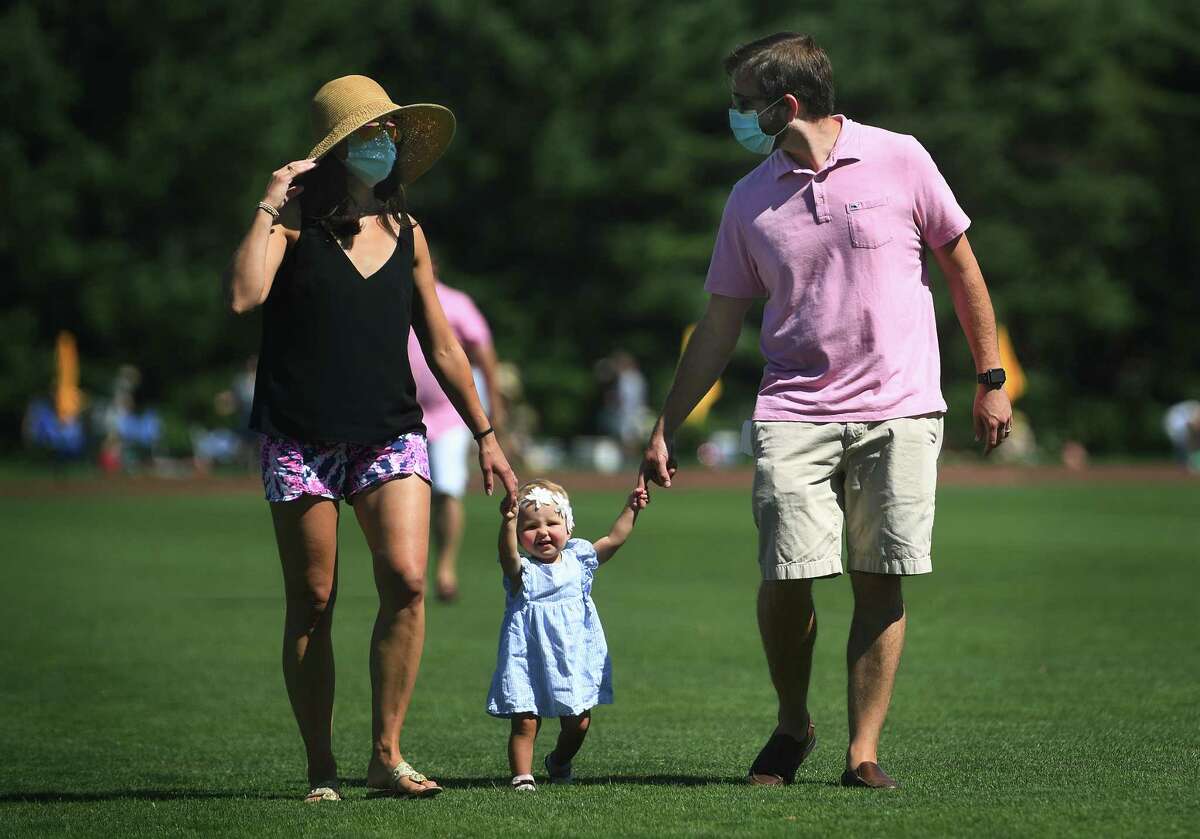 Kristina, Emilija, 16 months, and Ryan Loechner, of Stamford, go or a stroll at the East Coast Open Polo Championship at the Greenwich Polo Club in Greenwich, Conn. on Sunday, August 30, 2020.  Who will be issuing these fines? Local police, health departments and elected officials will be able to issue the fines.