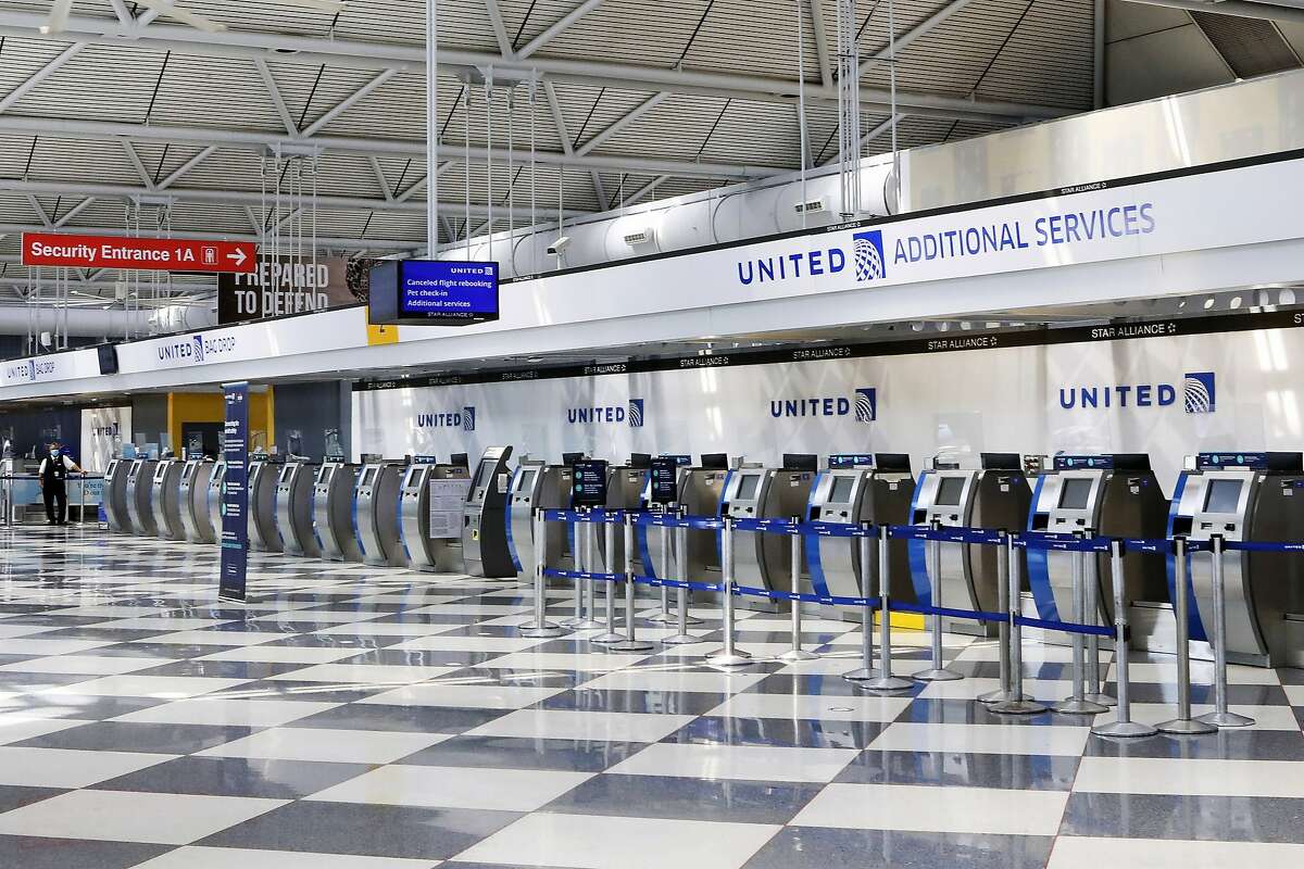 FILE - In this June 25, 2020, file photo, rows of United Airlines check-in counters at O'Hare International Airport in Chicago are unoccupied amid the coronavirus pandemic.