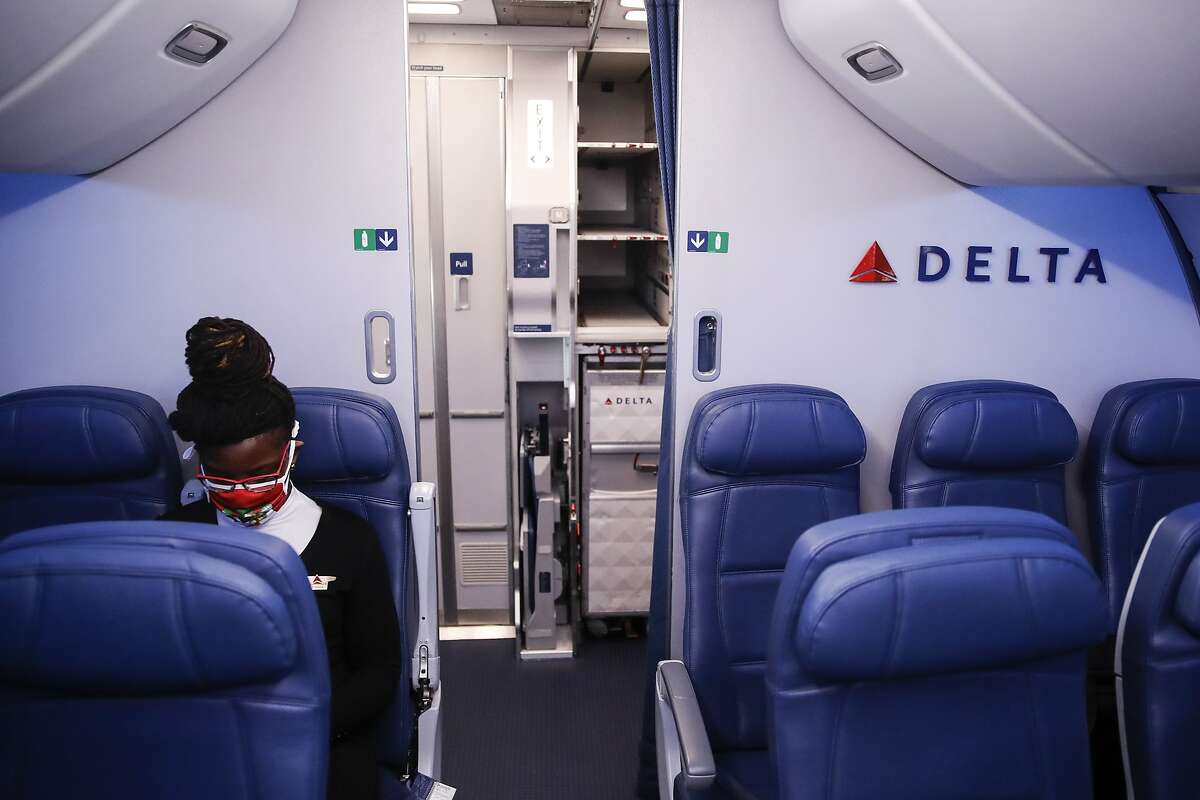 In this May 28, 2020, file photo, a Delta Airlines employee wears personal protective equipment after landing at Minneapolis-Saint Paul International Airport.