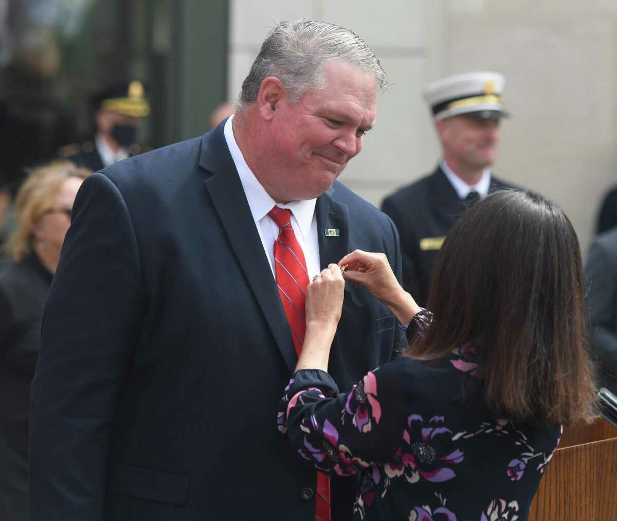 Incoming Fire Chief Joseph McHugh receives his pin during his swearing-in ceremony at the Public Safety Complex in Greenwich, Conn. Monday, Aug. 31, 2020. McHugh grew up in Greenwich and spent most of his career with the FDNY. The incoming Fire Chief will succeed Peter Siecienski, who retired in May, and begin his role on Sept. 14.