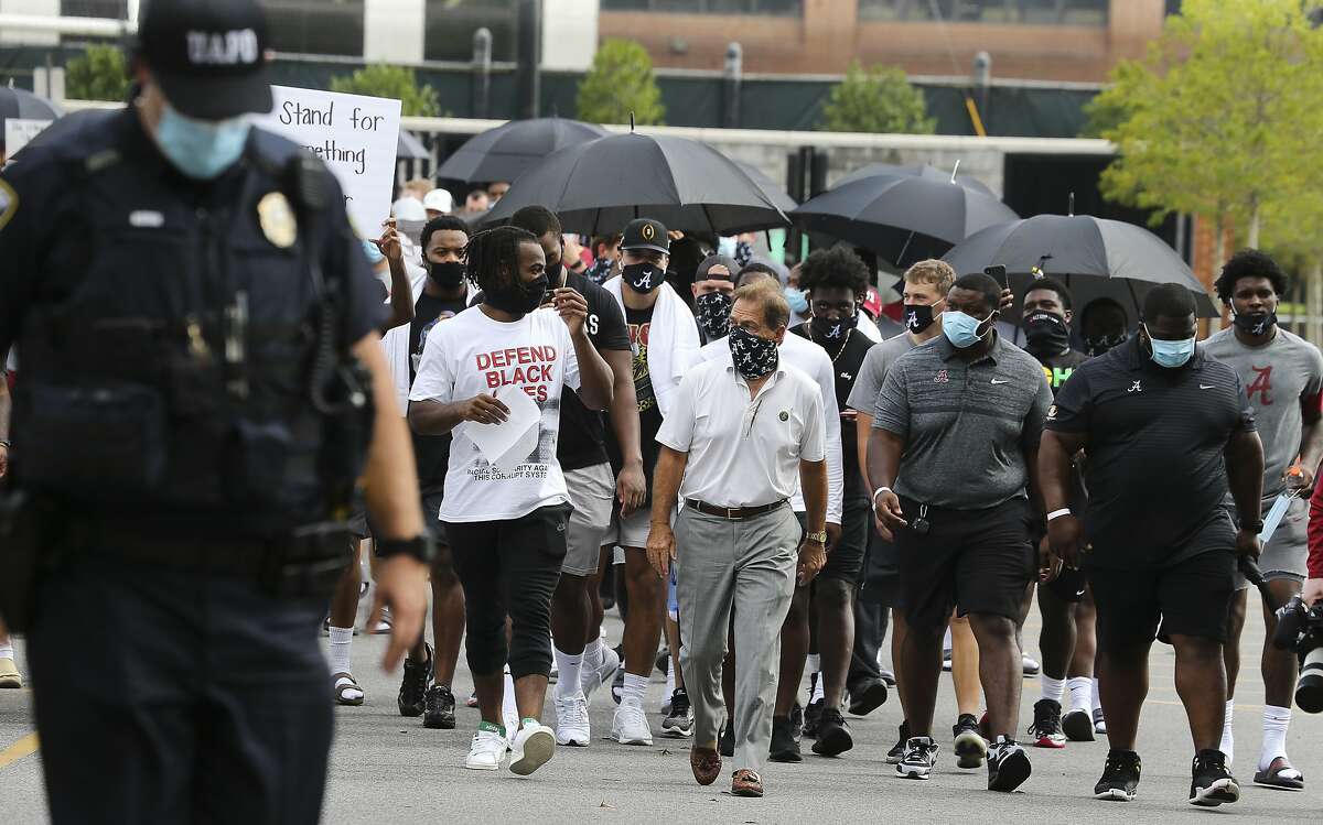 Coach Nick Saban and running back Najee Harris, left, lead the University of Alabama football team and other student athletes Monday, Aug. 31, 2020, in Tuscaloosa, Ala., as they march to Fosters Auditorium, the sight of the famous stand in the Schoolhouse Door to voice their support for social justice. (Gary Cosby Jr./The Tuscaloosa News via AP)