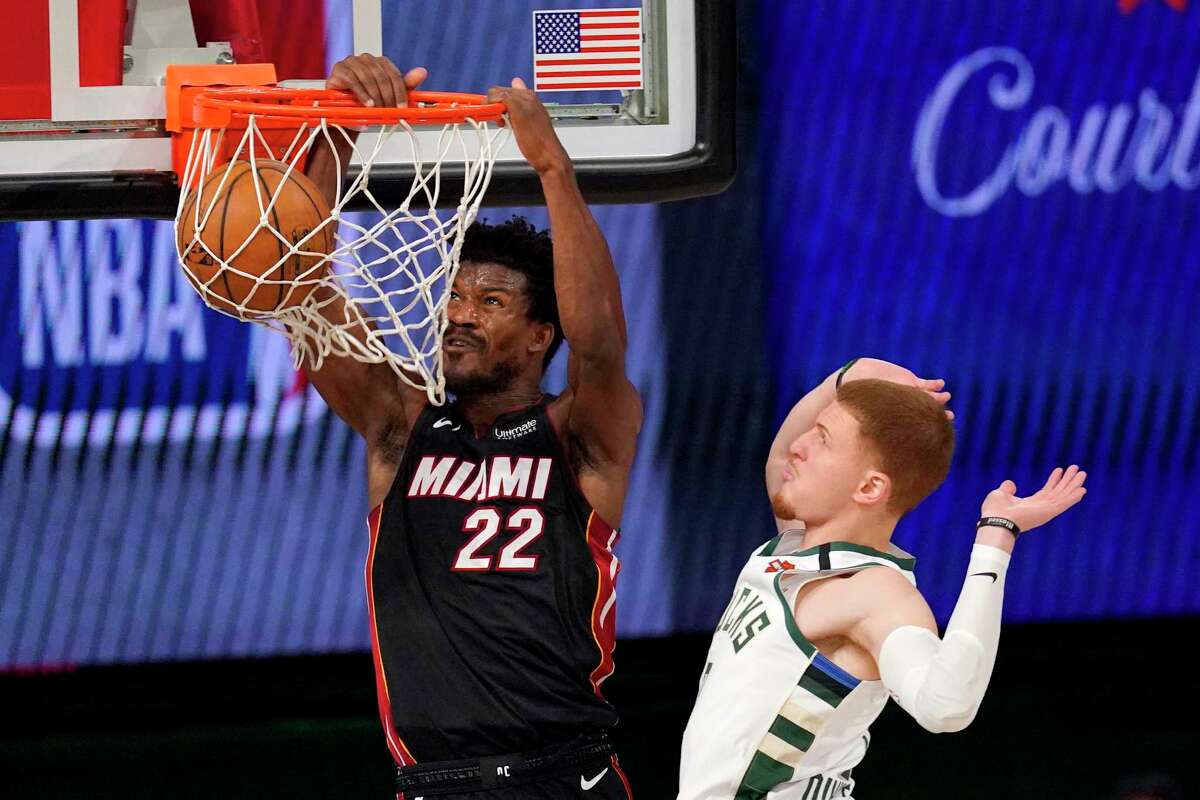 Miami Heat's Jimmy Butler (22) dunks the ball after getting past Milwaukee Bucks' Donte DiVincenzo (0) during the second half of an NBA basketball conference semifinal playoff game, Monday, Aug. 31, 2020, in Lake Buena Vista, Fla. (AP Photo/Mark J. Terrill)