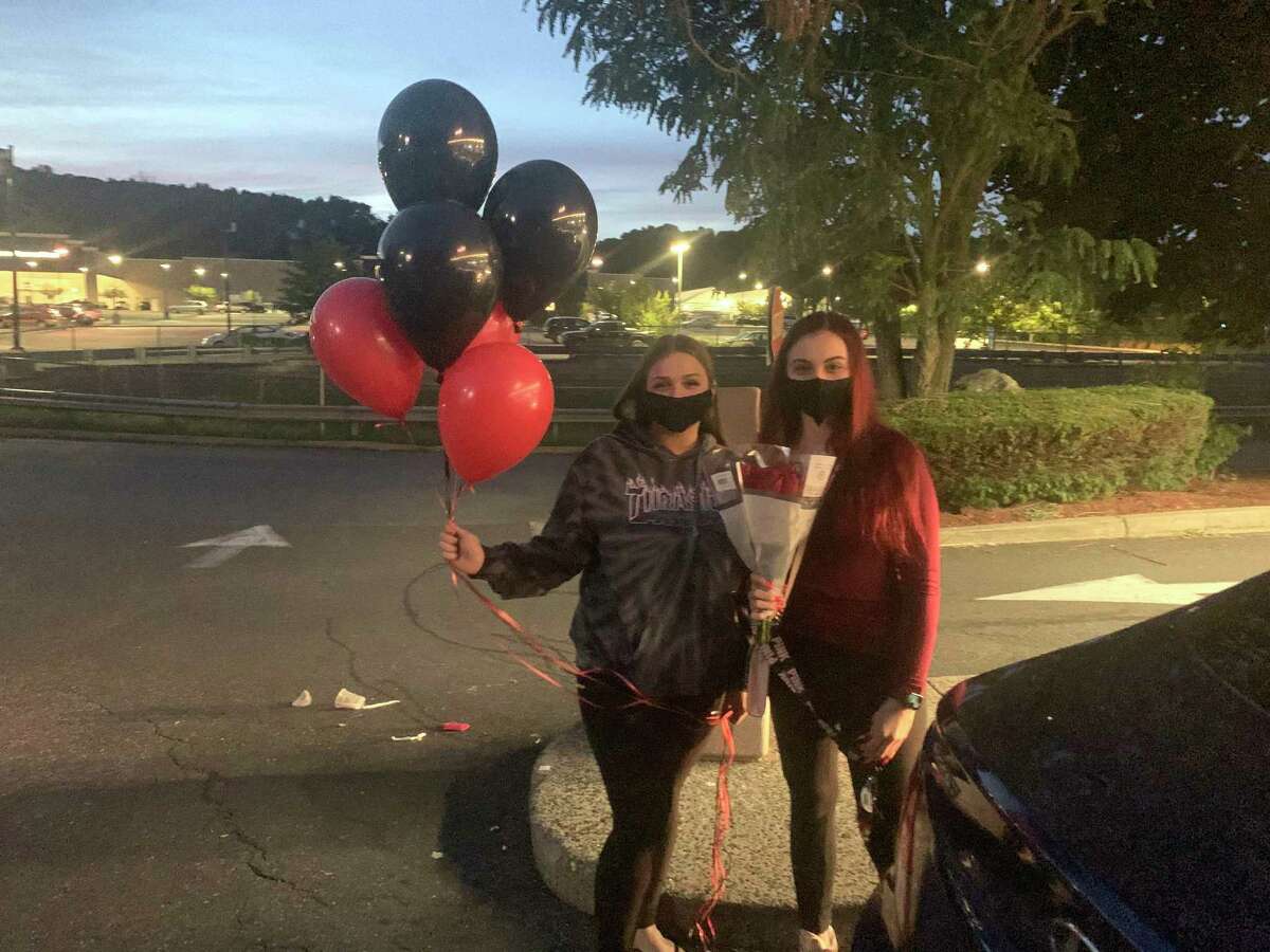 Tianna Greco of Shelton and Maria Evangelista of Stratford hold a group of red and blue balloons moments before they were among the dozens let go Monday night on Route 34 in Derby as a tribute to Rosali Aquefreda, the young Derby mother found stabbed to death in Ansonia Sunday.