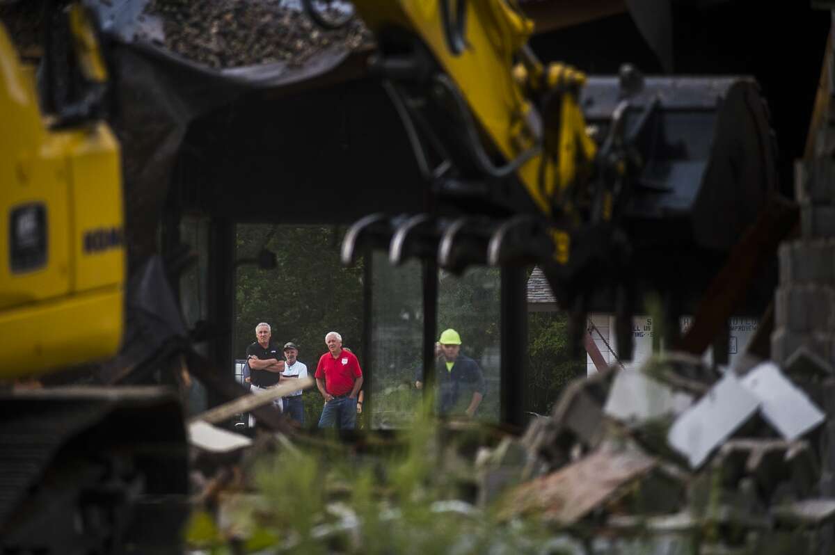 Denny Sian, Owner of Sanford Hardware, center, is joined by community members as the structure is demolished Tuesday, Sept. 1, 2020 in downtown Sanford. (Katy Kildee/kkildee@mdn.net)