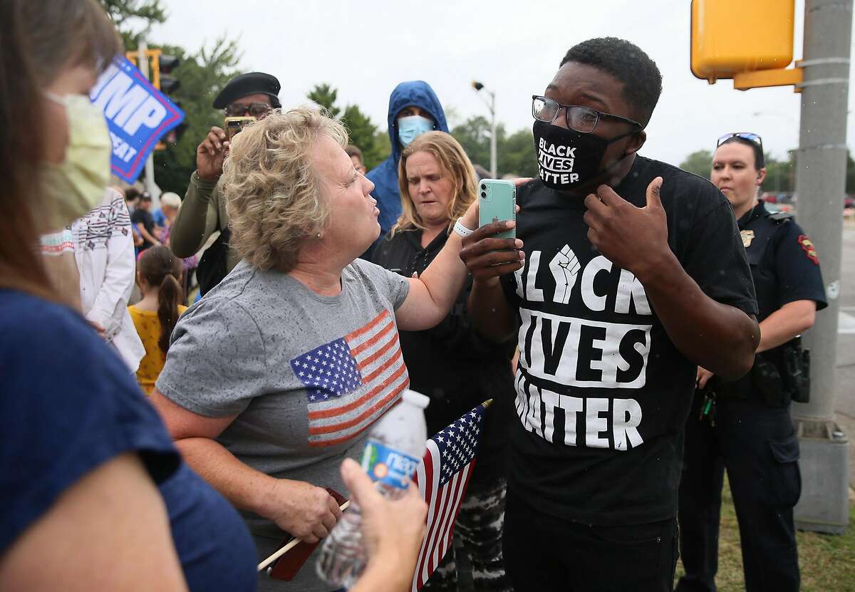 Supporters of President Donald Trump and a Black Lives Matter supporter face off as they wait for Trump's motorcade to pass outside of Mary D. Bradford High School in Kenosha, Wisconsin, on Tuesday, Sept. 1, 2020. (Stacey Wescott/Chicago Tribune/TNS)