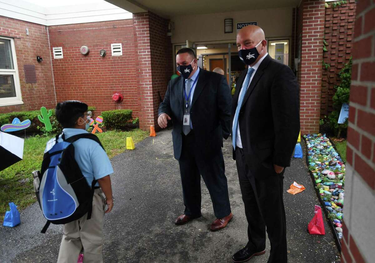 Ansonia Superintendent of Schools Joseph DiBacco, left, and Assistant Superintendent Stephen Bergin welcome students on the first day of school at Prendergast School in Ansonia. On Friday DiBacco shut the school down for two weeks because of COVID-19 infections.