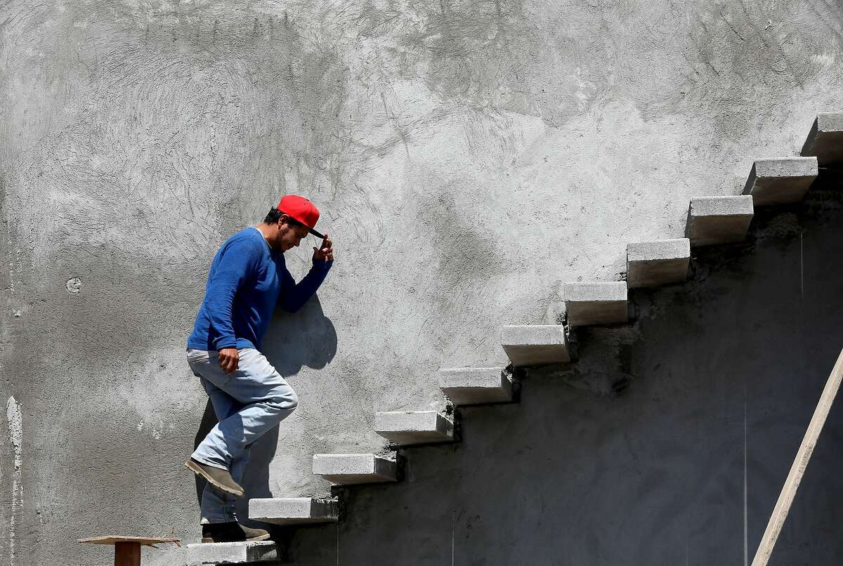 Jose Sergio, a construction worker, walks up a flight of steps as he heads to the roof at 2877 Rollo Rd. on Thursday, August 27, 2020, in Santa Rosa, Calif. Sara Harrison Woodfield is the architect of the home under construction.