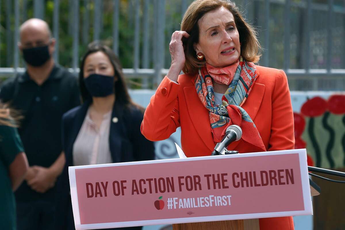 House Speaker Nancy Pelosi adjusts her hair in the breeze during a news conference at Mission Education Center.