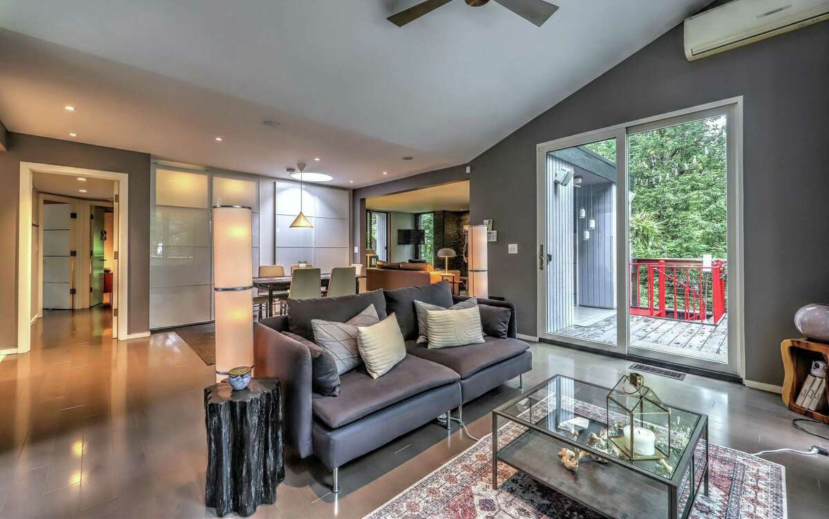 The family room has a vaulted ceiling, ceiling fan, and two sets of sliding doors to the large deck. Found on the main living level are the living room, dining room, kitchen, family room, and two of the four bedrooms. In the living room there is a wall of stone that houses a wood-burning stove and sliding doors to a balcony/deck. A second set of sliding doors lead to the larger deck. The family room has a vaulted ceiling, ceiling fan, and two sets of sliding doors to the large deck. The configuration of the dining room, which is open to the family room, allows it to accommodate elegant, intimate dinners as well as larger gatherings. In the kitchen there is radiant heat flooring, plenty of counter space and cabinets, and under cabinet lighting.