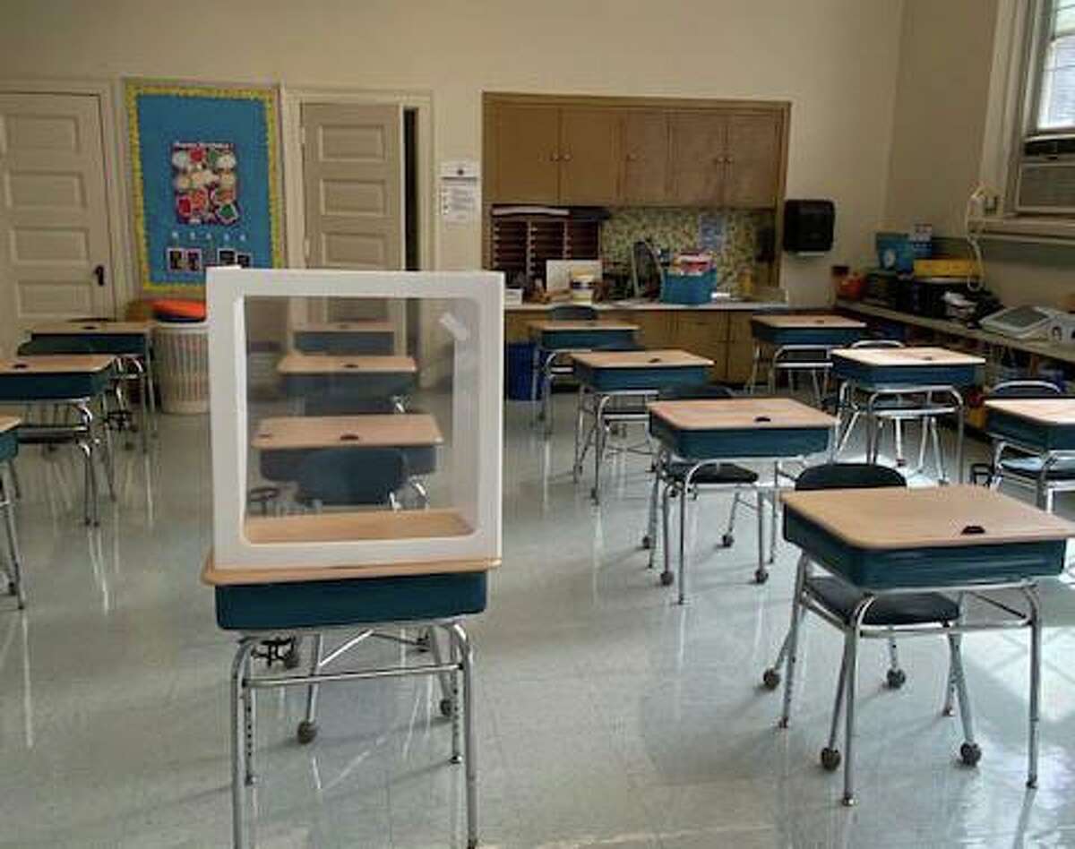 A desk with an individual divider set up in an Old Greenwich School classroom.