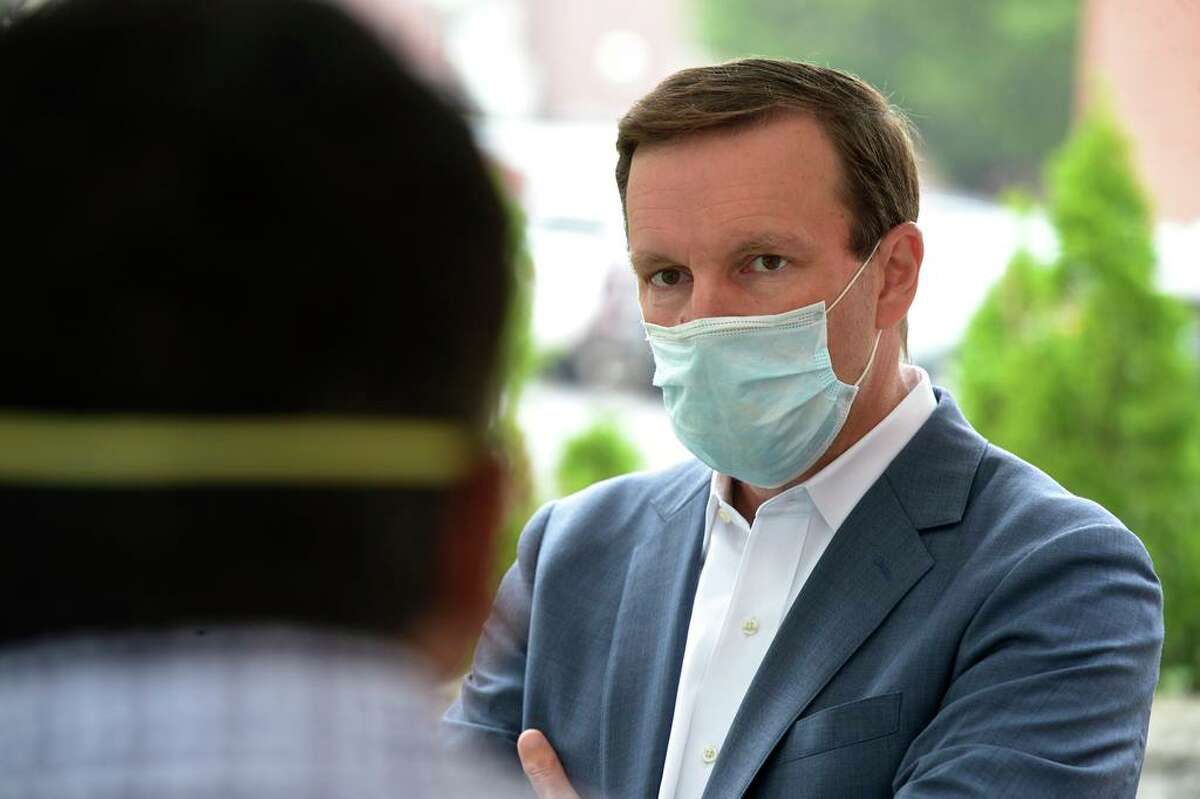 U.S. Sen. Chris Murphy listens to Shinu Simon, Administrative Director of the community health center Connecticut Institute for Communities, during a visit to the facility to promote increased COVID-19 testing. Friday, July 17, 2020, in Danbury, Conn.