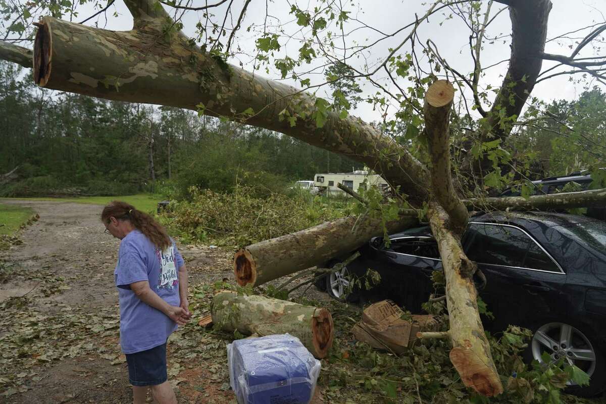 A person stands in front of a vehicle damaged by a fallen tree after Hurricane Laura made landfall near Orange, Texas, U.S., on Friday, Aug. 28, 2020. Hurricane Laura, one of the most powerful storms ever to hit Louisiana, left a path of chemical fires, wrecked buildings, flooded roads and what could be more than $15 billion in insured losses, with reports of at least six people dead. Photographer: Go Nakamura/Bloomberg