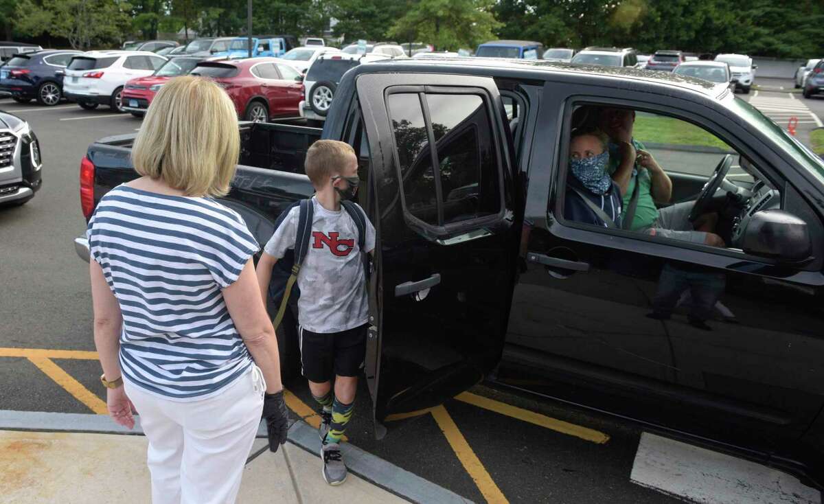 A student is dropped off on the first day of the new school year at South Elementary School in New Canaan, Conn, Monday, August 31, 2020.