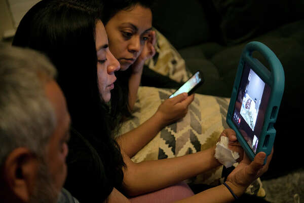 The nurses helped Nora videoconference with her family every night. Shown are Enrique, from left, Vanessa and Alex on a call with Nora.