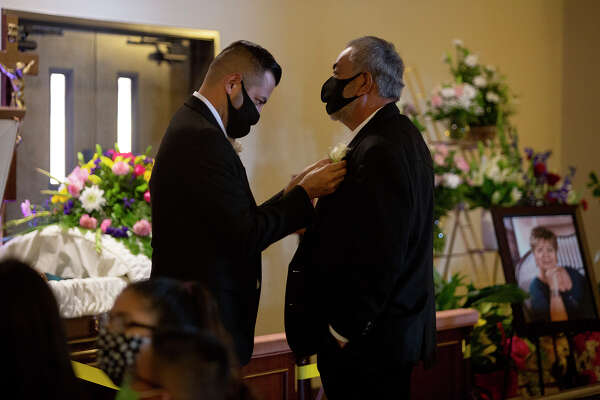Andy pins a flower on his father’s lapel before the Aug. 1 funeral service for Nora, shown in the photo at right.