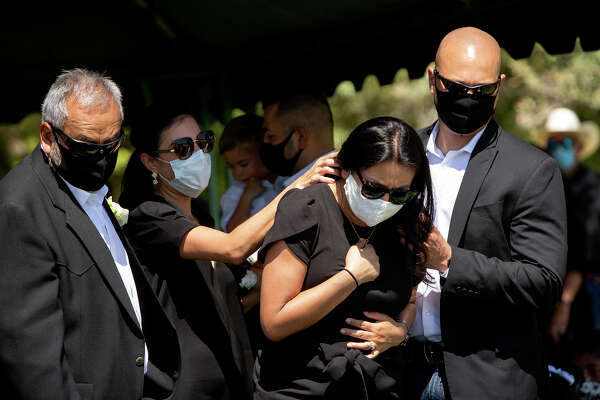 Vanessa, center, grieves for her mother during Nora's burial service. Her father, Enrique, is on the left.
