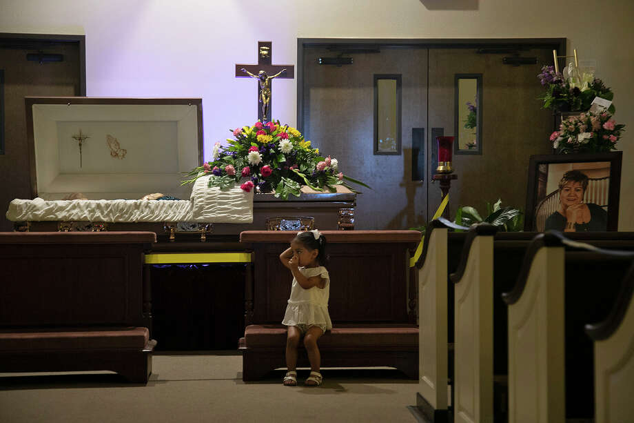 Sophia Dyer, 2, sits in front of the casket holding her grandmother, Nora, shown in photo at right, during the July 31 visitation and rosary at Trinity Mortuary in Del Rio. Photo: Lisa Krantz, Staff Photographer / San Antonio Express-News