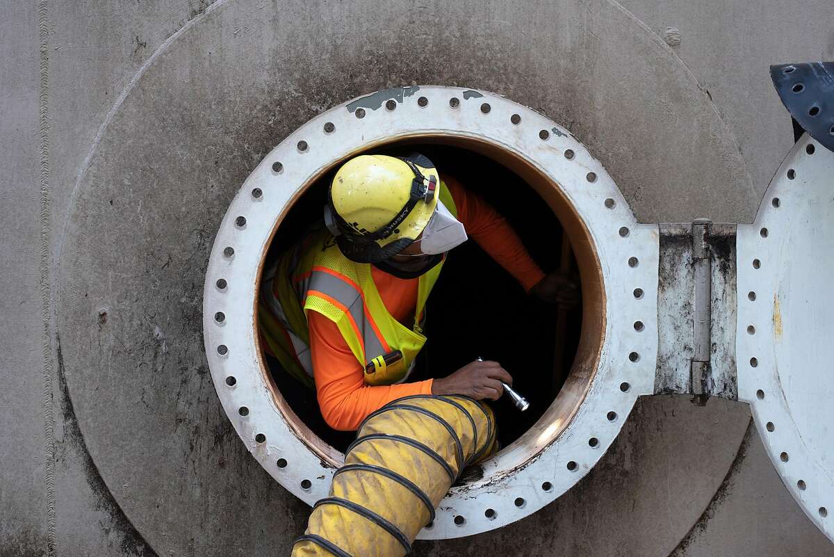 Jack Duarte from San Jose based underground utility construction company Lewis and Tibbits Inc. works on a San Lorenzo Valley Water District tank after the CZU Lightning Complex Fire destroyed some of the infrastructure in Boulder Creek on Sept. 3, 2020.