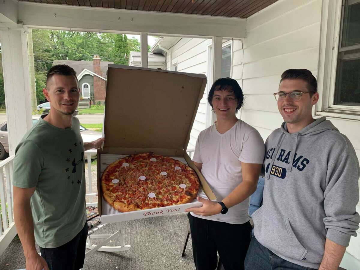 Nathan Ames returned 2,690 bottles, raising $269 for Midland's Open Door. On Sept. 1, Open Door staff, joined by Ames's youth pastors, Karl Sorget and Jake Singer, surprised him on his front doorstep with a monster meat lover's pizza from Pizza Dude. (Photo provided)