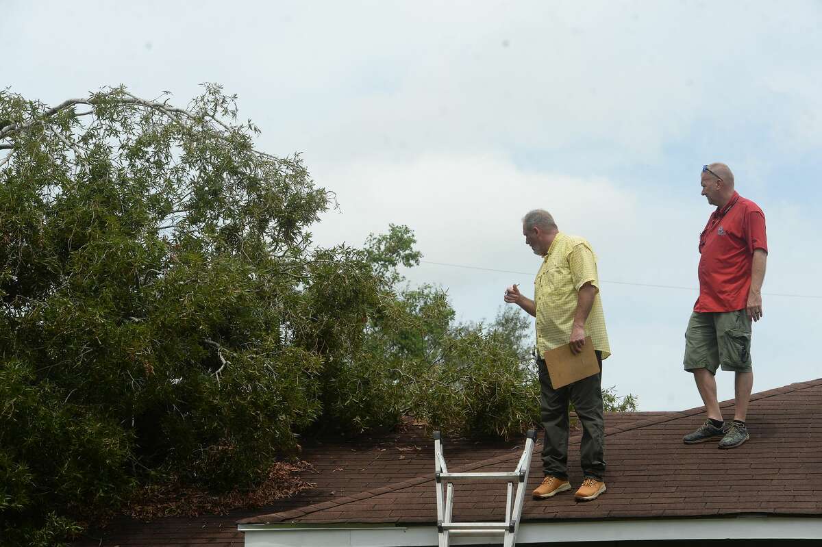 Johnny Hancock and Donnie Hallman, insurance adjusters, survey damage done from a fallen tree atop a home in Orange a week after the area was hit with some of the most severe damage in Southeast Texas by Hurricane Laura. The pair had just arrived in Orange to meet with clients after working in Lake Charles. Photo taken Thursday, September 3, 2020 Kim Brent/The Enterprise