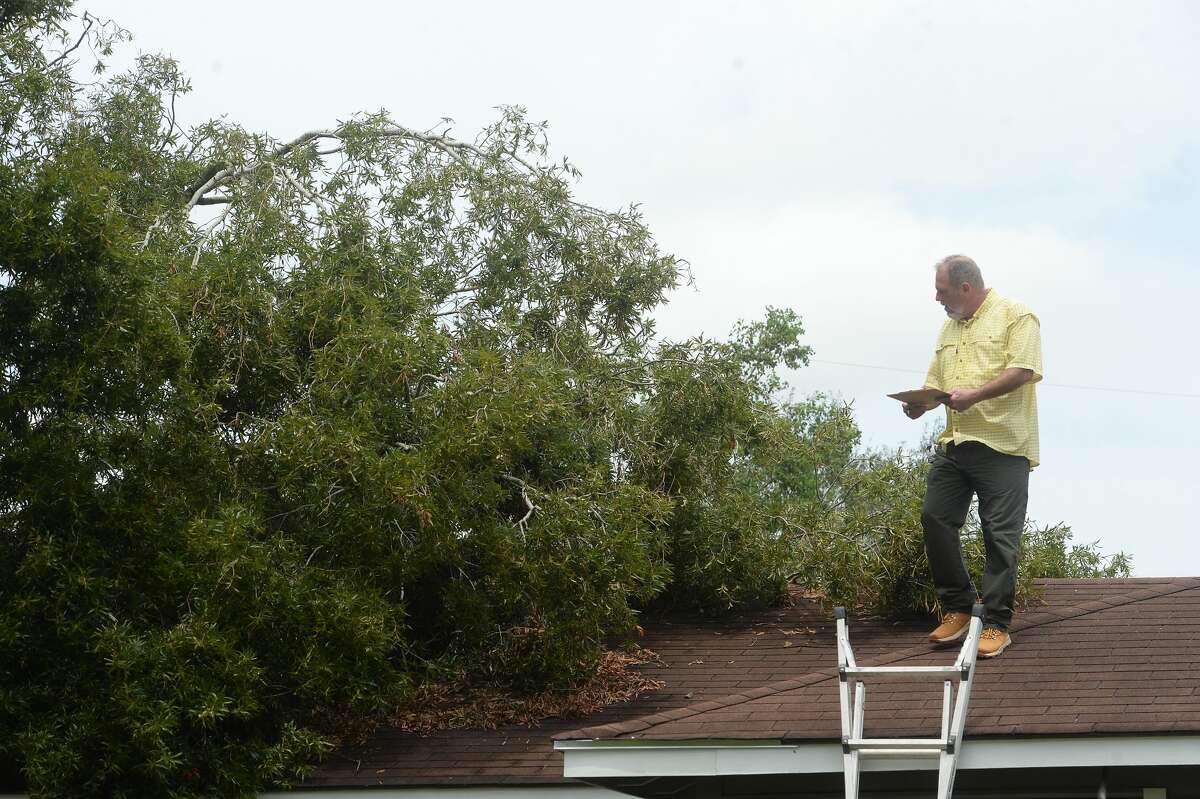 Johnny Hancock, an insurance adjuster, makes notes as he surveys damage done from a fallen tree atop a home in Orange a week after the area was hit with some of the most severe damage in Southeast Texas by Hurricane Laura. Photo taken Thursday, September 3, 2020 Kim Brent/The Enterprise