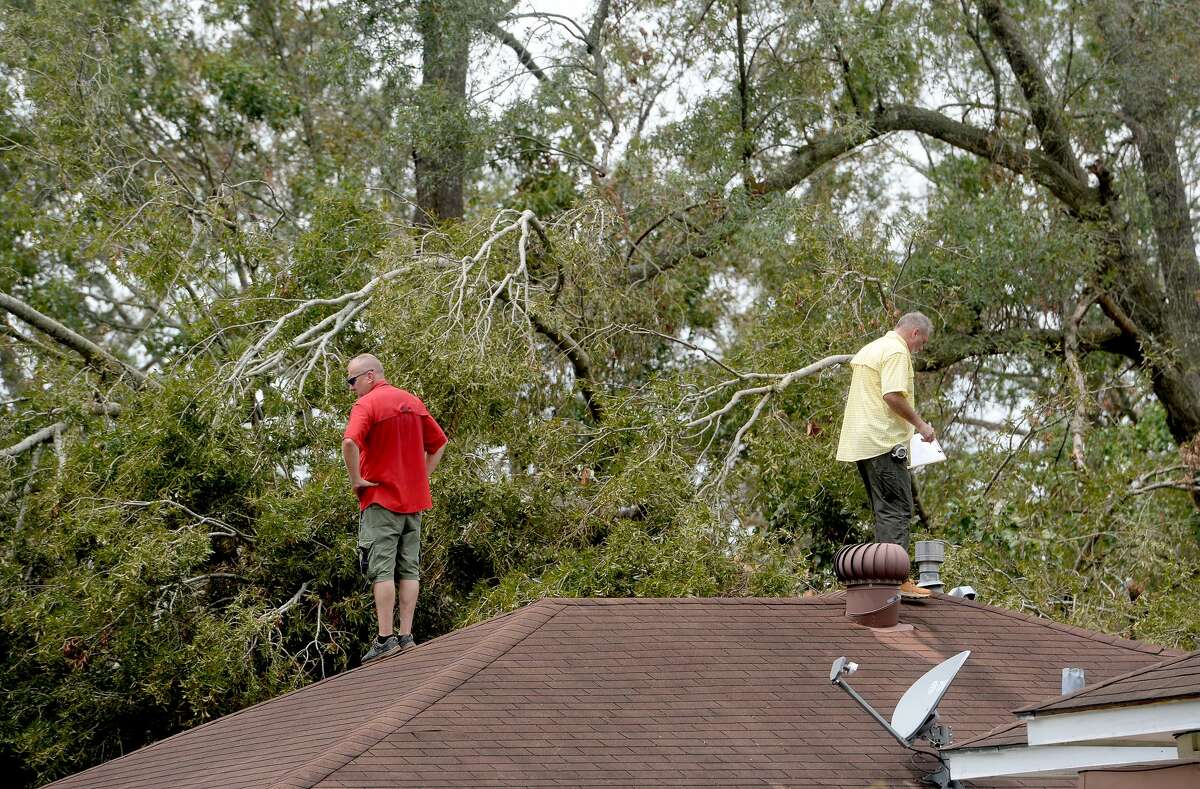 Insurance adjusters Donnie Hallman (left) and Johnny Hancock survey the roof of a home in Orange where a tree crashed above the garage as work continues a week after the area was hit with some of the most severe damage in Southeast Texas by Hurricane Laura. Photo taken Thursday, September 3, 2020 Kim Brent/The Enterprise