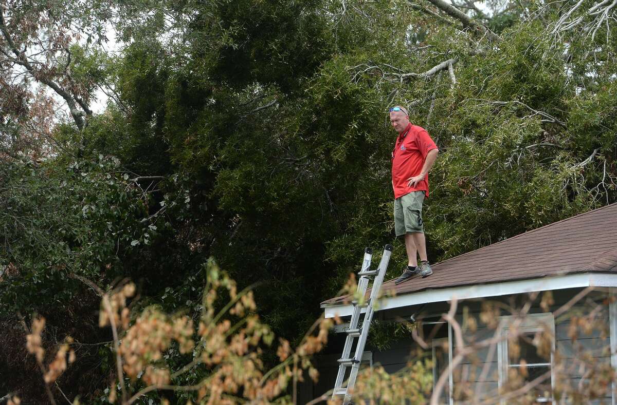 Insurance adjuster Donnie Hallman surveys the roof of a home in Orange where a tree crashed above the garage as work continues week after the area was hit with some of the most severe damage in Southeast Texas by Hurricane Laura. Photo taken Thursday, September 3, 2020 Kim Brent/The Enterprise