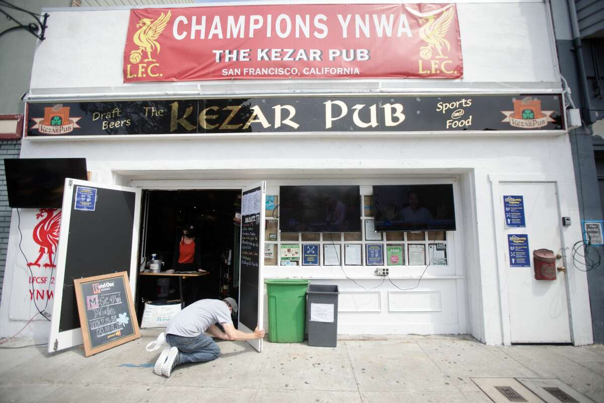 Customer Richie McAllister helps put a wedge underneath the door of the Kezar Pub on Sept. 3, 2020 in San Francisco, California.