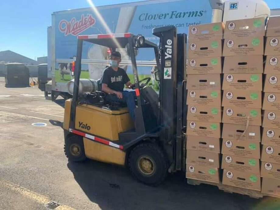 A forklift operator moves some of the 1,500 boxes containing fresh fruits and vegetables which were distributed in August. Residents came come to Wade’s Dairy, 1316 Barnum Avenue on Labor for another free distribution. Photo: / Harry Bell /contributed Photo