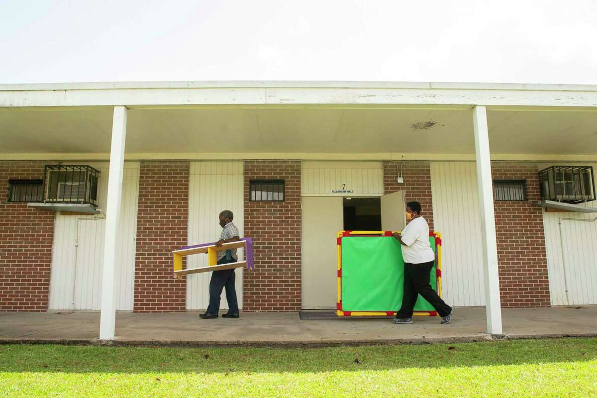 Volunteer Charles Cave and executive pastor Enid Henderson carry pieces of furniture into a classroom, Tuesday, Sept. 1, 2020, at Jones Memorial United Methodist Church's Crestmont Park campus in Houston. The church is partnering with HISD this fall to provide space for students to learn with church volunteers and HISD staff.