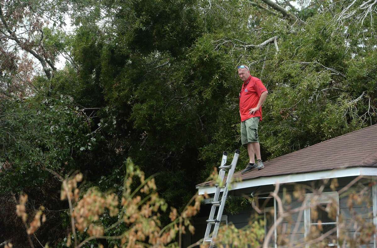 Insurance adjuster Donnie Hallman surveys the roof of a home in Orange where a tree crashed above the garage as work continues week after the area was hit with some of the most severe damage in Southeast Texas by Hurricane Laura. Photo taken Thursday, September 3, 2020 Kim Brent/The Enterprise