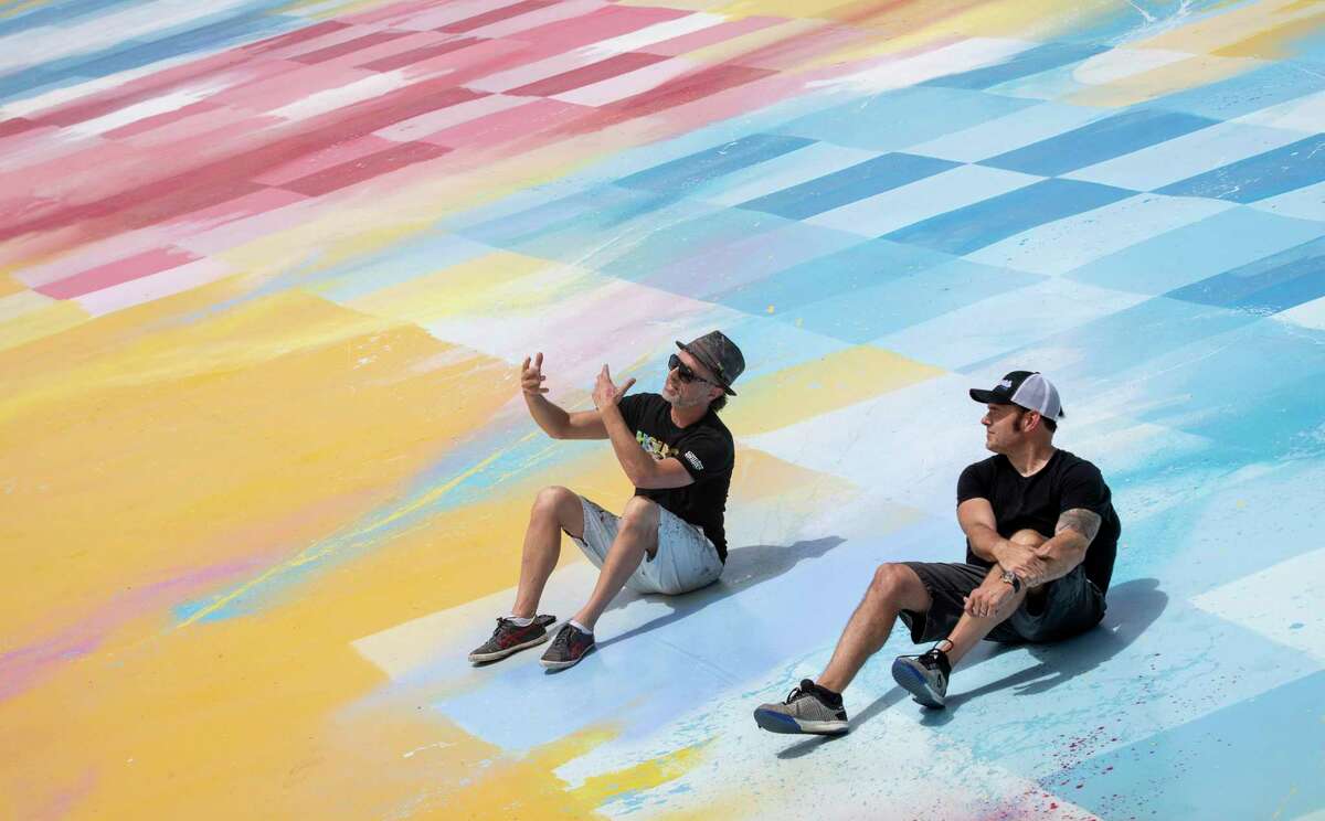 Sebastien “Mr D 1987” Boileau, left, and Rick Williams, founder and CEO of Joyride, talk on the roof of Williams’ building, where Boileau painted a large mural, Wednesday, Sept. 2, 2020, in Houston.