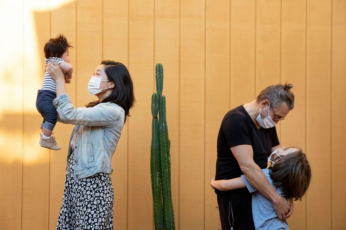 Deborah Tu, left, holds up her son Andre, 3 months, while Joey Jelenik, right, hugs his son Jax, 6, at Tu�s home in San Francisco, Calif., Thursday, Sept. 3, 2020. Tu and Jelenik are the founders of NurturePods.org which matches families with pandemic learning pods.