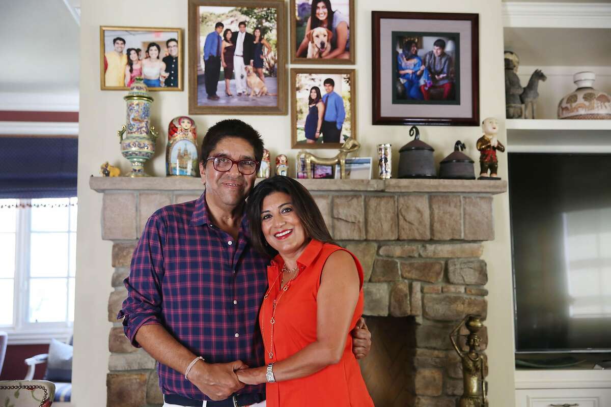Atulya (left) and Seema Sarin stand in their Los Altos home filled with family photos. The couple, who were brought together through an arranged marriage, wed in 1988.