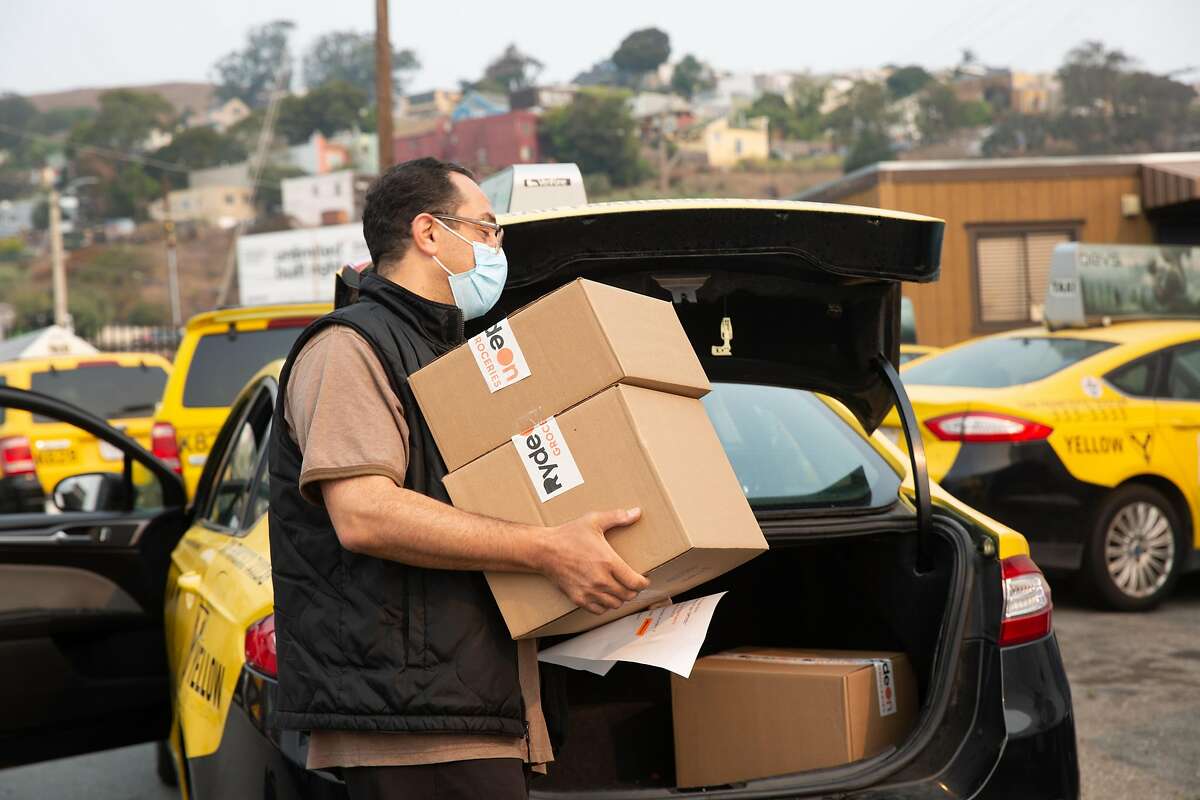 Rachid Missoui, a Taxi driver for Yellow Cab San Francisco, packs his cab with boxes of fresh vegetables that he will deliver to customers of San Francisco based startup RydeOn. On Monday, Aug. 24, 2020 in San Francisco, California.