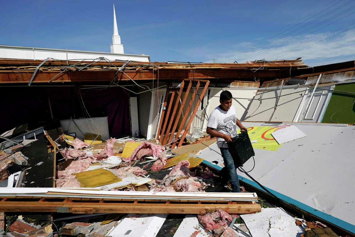 Benjamin Luna helps recover items from the children's wing of the First Pentecostal Church that was destroyed by Hurricane Laura, Thursday, Aug. 27, 2020, in Orange, Texas. (AP Photo/Eric Gay)