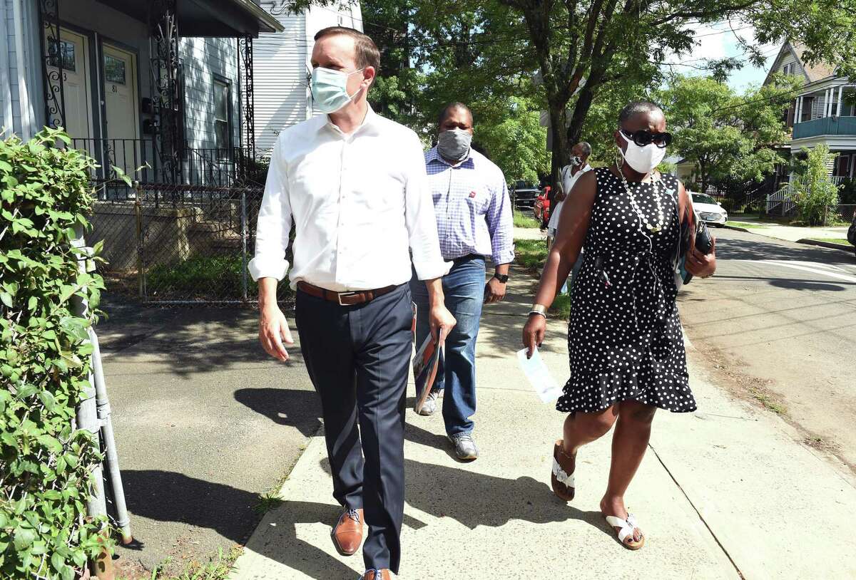 From left, U.S. Sen. Chris Murphy goes door-to-door distributing census information on Thompson Street in New Haven with state Sen. Gary Winfield and state Rep. Robyn Porter on Sept. 4, 2020.