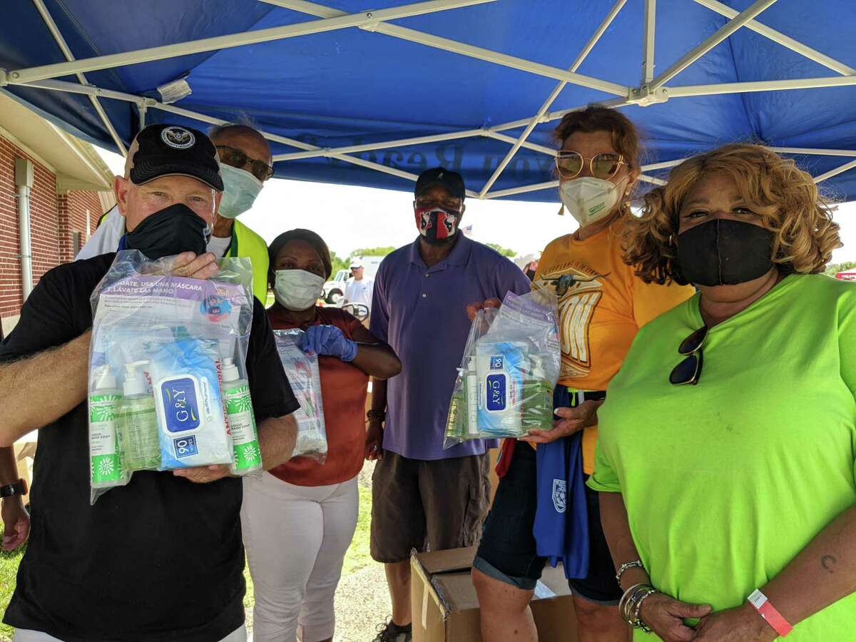 Residents show off their personal protection equipment kits provided by Fort Bend County on Friday at Four Corners Recreation Center in Sugar Land.
