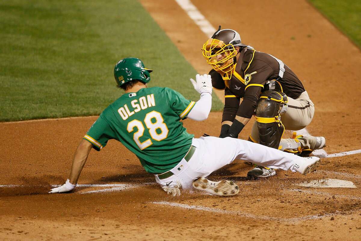 Oakland Athletics first baseman Matt Olson (28) slides to home plate against San Diego Padres catcher Austin Nola (22) in the fourth inning of an MLB game at RingCentral Coliseum on Friday, Sept. 4, 2020, in Oakland, Calif. Initially called safe, Olson was ruled out after official review of the play.