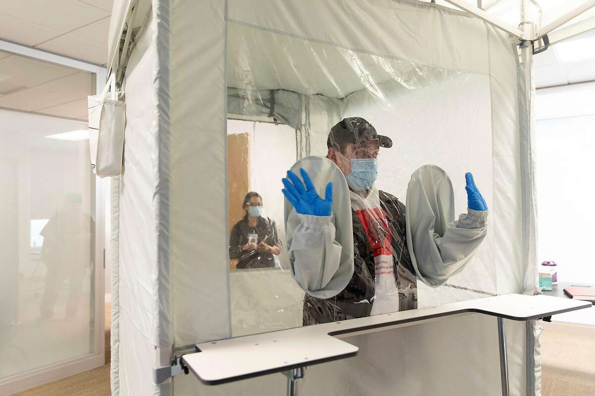 Rafael Gonzalez, a community program manager with Bridge HIV, checks out the new tent that will allow him and his co-workers to safely get nasal swabs from COVID19 vaccine trial participants at Bridge HIV in San Francisco, Calif., Thursday, Sept. 3, 2020.
