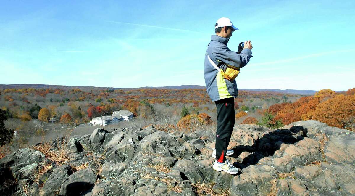 A hiker takes a photograph on a rock summit at Sleeping Giant State Park in Hamden during the Fall Hikers' Hike hosted by the Sleeping Giant Park Association in November 2008.