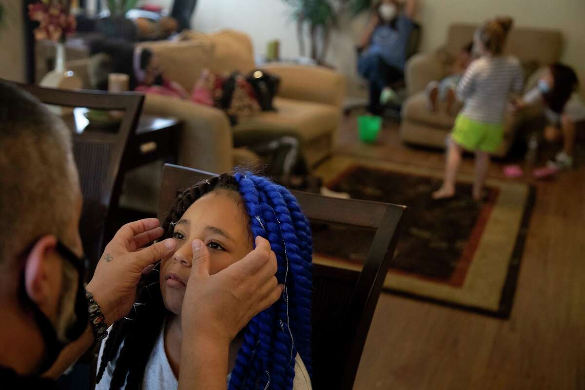A.J. Martinez gives Juliana Byrd, 8, a facial at Avistar at the Oaks apartments in San Antonio on Thursday, Sept. 3, 2020. Martinez is a resident of the apartment complex and has been out of work due to COVID-19 but is opening his own stall at Mike's Hair Lounge soon.