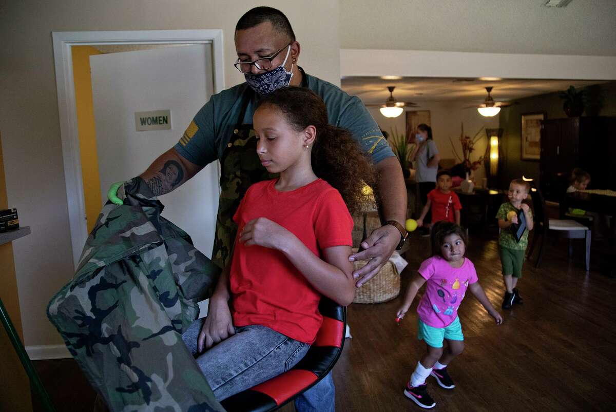 Juan Rodriguez pulls a cape off Abigail Sizenbach, 10, after he cut her hair at Avistar at the Oaks apartments in San Antonio on Thursday, Sept. 3, 2020. Rodriguez is a resident there who lost his job working in an oil field in February due to COVID-19. Sizenbach lives in another Avistar apartment complex nearby with her family including sister Mariska Sizenbach, 3, right.