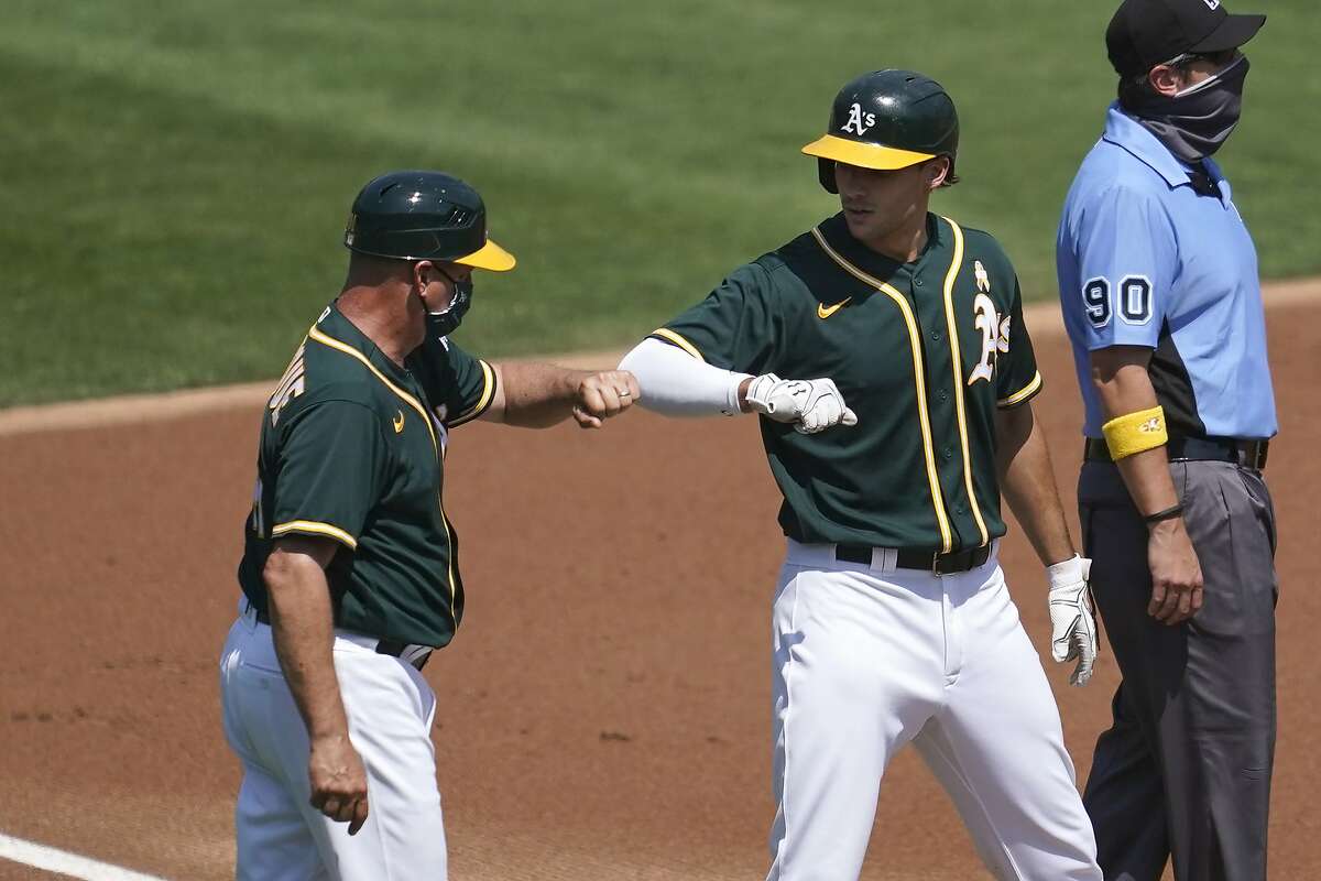 Oakland Athletics' Matt Olson, front right, is congratulated by third base coach Al Pedrique after hitting a two-run triple against the San Diego Padres during the first inning of a baseball game in Oakland, Calif., Saturday, Sept. 5, 2020. (AP Photo/Jeff Chiu)