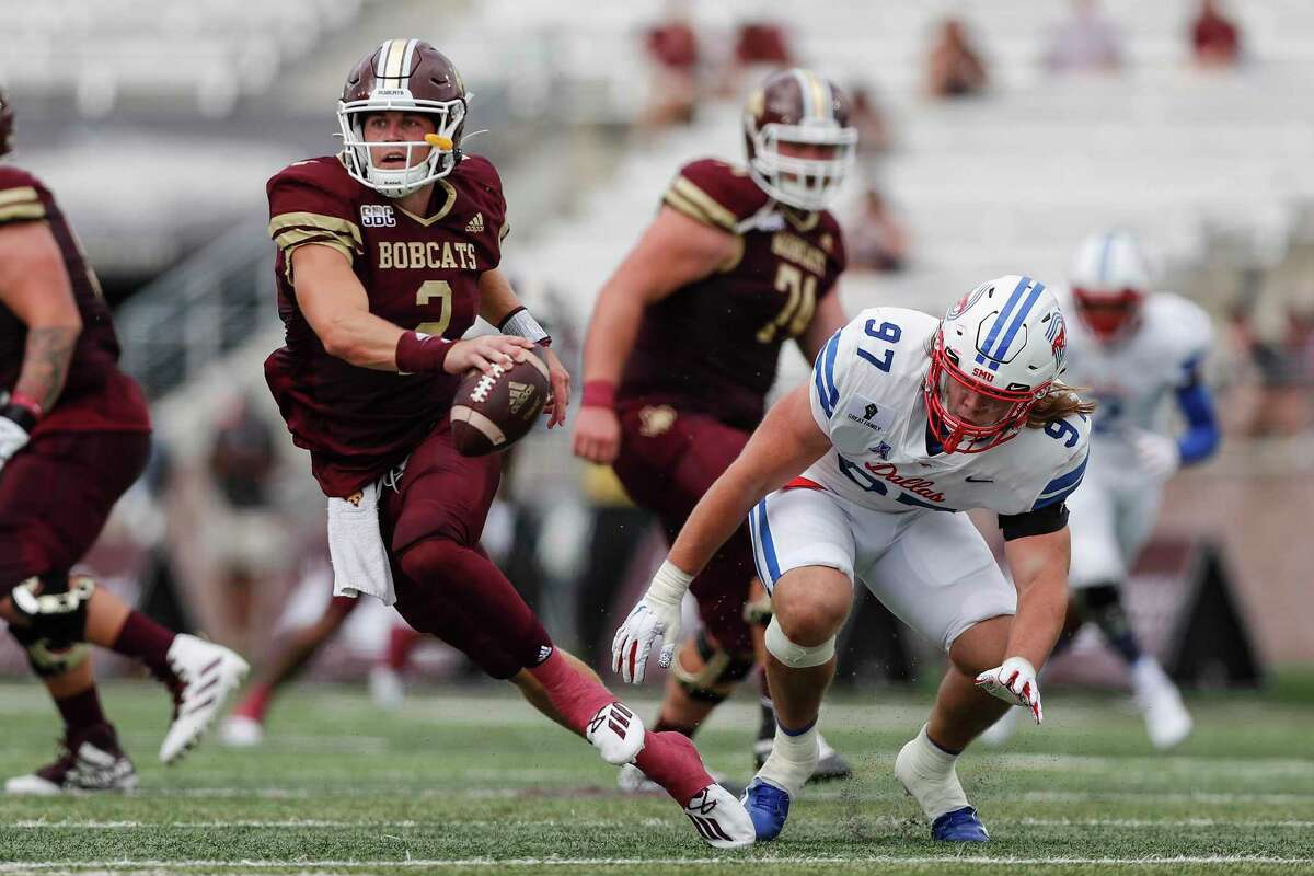 SAN MARCOS, TEXAS - SEPTEMBER 05: Brady McBride #2 of the Texas State Bobcats escapes the pressure by Turner Coxe #97 of the Southern Methodist Mustangs in the first half at Bobcat Stadium on September 05, 2020 in San Marcos, Texas. (Photo by Tim Warner/Getty Images)