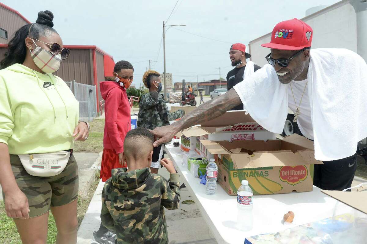 Port Arthur native and NBA player Stephen Jackson greets a young volunteer as he with Feed Your City Challenge's food and supply distribution to those impacted by Hurricane Laura in Port Arthur. Photo taken Saturday, September 5, 2020 Kim Brent/The Enterprise