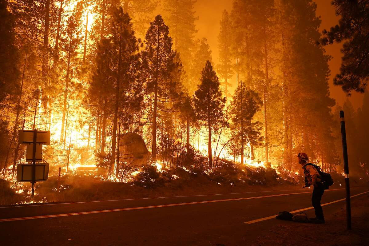 Gabe Huck, right, a member of a San Benito Monterey Cal Fire crew, stands along state Highway 168 while fighting the Creek Fire, Sunday, Sept. 6, 2020, in Shaver Lake, Calif. (AP Photo/Marcio Jose Sanchez)